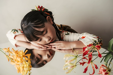 鏡に映る自分と花を見つめる着物姿の女の子